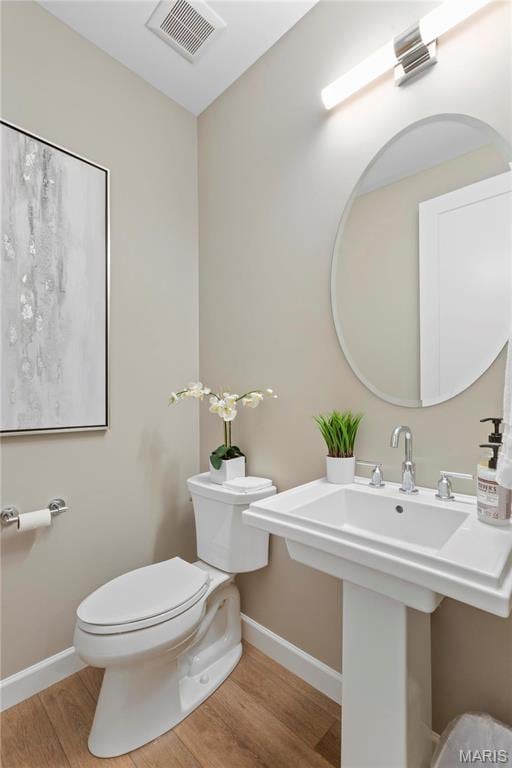 303 Clewer Park Ct, Lake St Louis, MO 63367 - bathroom featuring toilet, wood finished floors, and baseboards