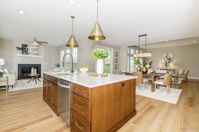 303 Clewer Park Ct, Lake St Louis, MO 63367 - kitchen featuring dishwasher, a sink, open floor plan, ceiling fan, and light wood-style flooring