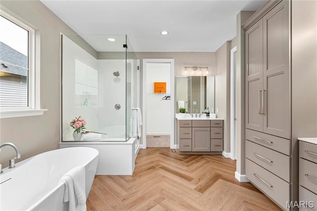 303 Clewer Park Ct, Lake St Louis, MO 63367 - full bath with a stall shower, vanity, a freestanding bath, plenty of natural light, and recessed lighting