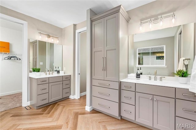 303 Clewer Park Ct, Lake St Louis, MO 63367 - bathroom featuring two vanities, baseboards, and track lighting