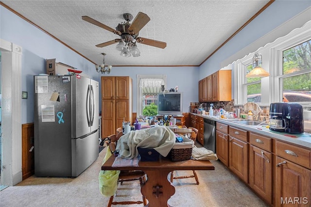883 Biltmore St, Saint Genevieve, MO 63670 - kitchen featuring appliances with stainless steel finishes, ornamental molding, brown cabinets, a ceiling fan, and light carpet