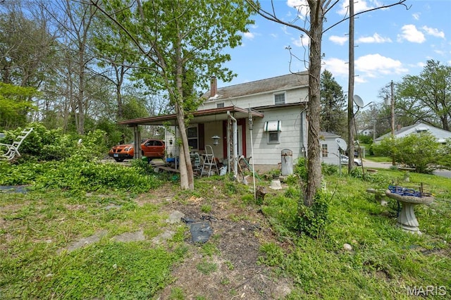 883 Biltmore St, Saint Genevieve, MO 63670 - back of property with an attached carport and a chimney