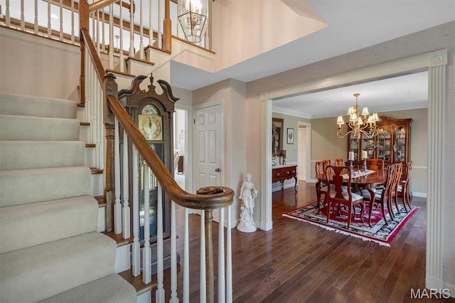 stairs featuring baseboards, wood finished floors, a chandelier, and ornamental molding
