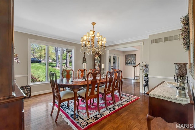 dining space with a chandelier, dark wood-type flooring, ornamental molding, and baseboards