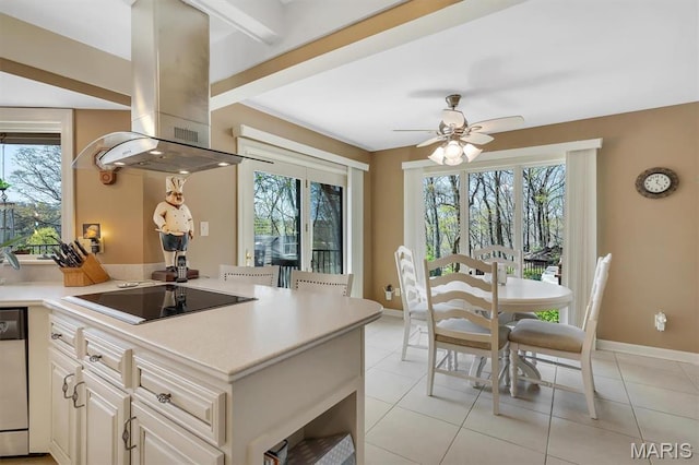 kitchen with black electric stovetop, island range hood, plenty of natural light, and light countertops