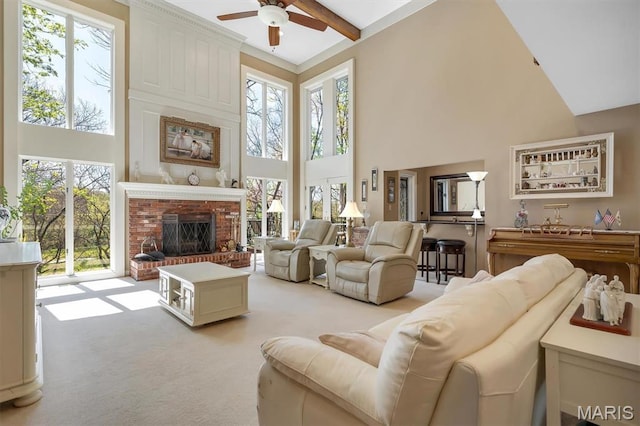 living room featuring a high ceiling, ceiling fan, healthy amount of natural light, light colored carpet, and a brick fireplace