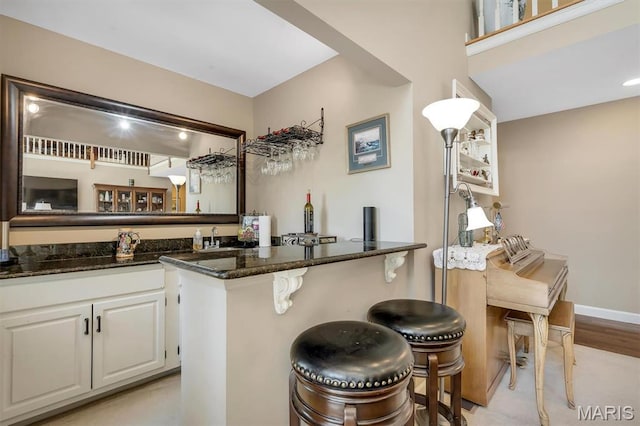 indoor wet bar with light wood-type flooring