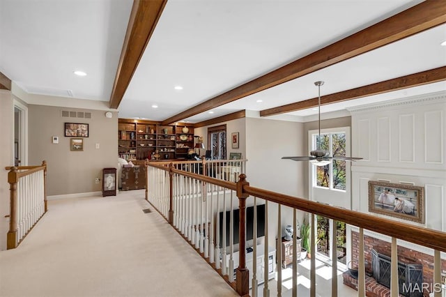 hall featuring an upstairs landing, baseboards, beamed ceiling, recessed lighting, and light colored carpet