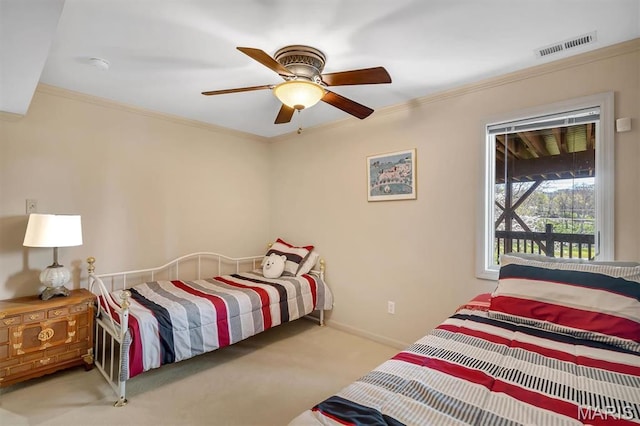 carpeted bedroom with crown molding, baseboards, and ceiling fan