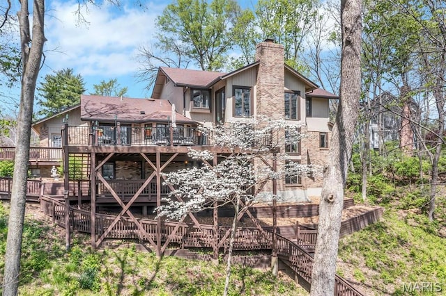 rear view of property with stairs, a wooden deck, and a chimney