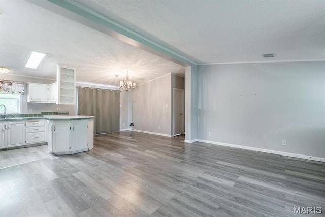 1340 Denmark Rd, Union, MO 63084 - kitchen with a chandelier, a sink, white cabinets, light wood-style flooring, and light countertops