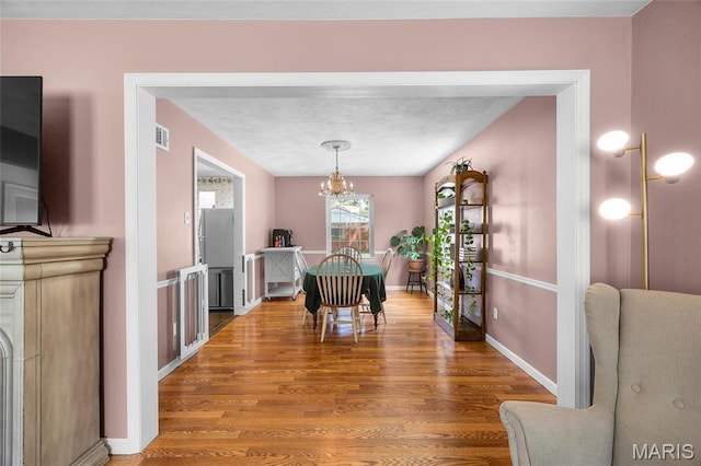 6623 Neosho St, Saint Louis, MO 63109 - dining area with wood finished floors, a chandelier, and baseboards