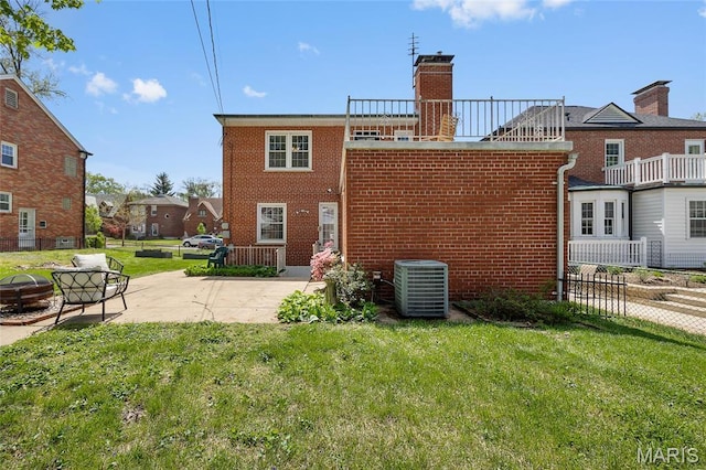 6623 Neosho St, Saint Louis, MO 63109 - rear view of house featuring central AC unit, brick siding, a patio, and a chimney