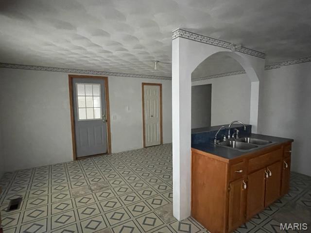 515 S Main St, Fredericktown, MO 63645 - kitchen featuring a sink, dark countertops, arched walkways, and brown cabinets