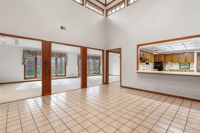 3581 Jarvis Rd, Hillsboro, MO 63050 - unfurnished living room with baseboards, a towering ceiling, a sink, and light tile patterned floors
