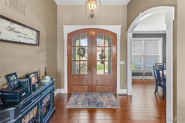 7048 Alston Ct, Edwardsville, IL 62025 - foyer featuring french doors, arched walkways, wood finished floors, baseboards, and a chandelier