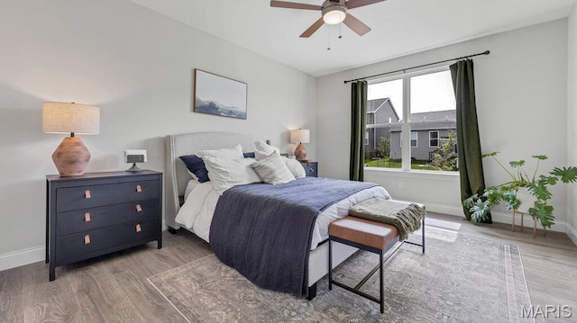 bedroom with baseboards, wood finished floors, and a ceiling fan