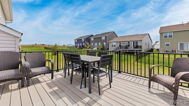 wooden deck featuring a residential view, a yard, and outdoor dining area