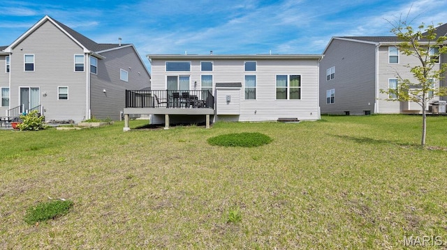 rear view of property with a wooden deck and a lawn