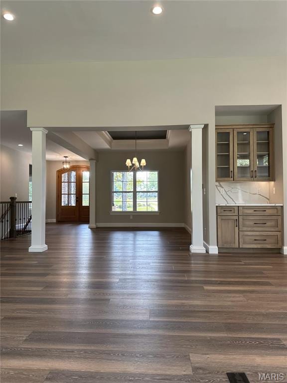 11906 Santino Ct, Creve Coeur, MO 63141 - unfurnished dining area featuring baseboards, decorative columns, dark wood-style flooring, a raised ceiling, and a chandelier