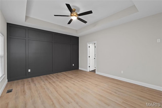 11906 Santino Ct, Creve Coeur, MO 63141 - unfurnished room featuring a raised ceiling, baseboards, light wood-style flooring, and a ceiling fan
