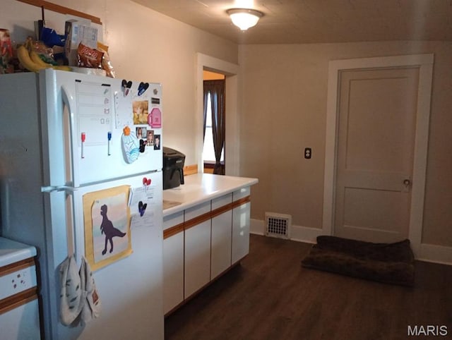 306 Kingshighway, East Alton, IL 62024 - kitchen with freestanding refrigerator, dark wood-type flooring, light countertops, white cabinetry, and baseboards