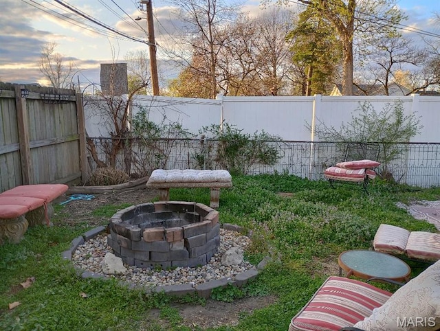 306 Kingshighway, East Alton, IL 62024 - yard at dusk featuring a fenced backyard and an outdoor fire pit