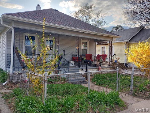 306 Kingshighway, East Alton, IL 62024 - view of front facade featuring covered porch, a fenced front yard, a gate, and a chimney