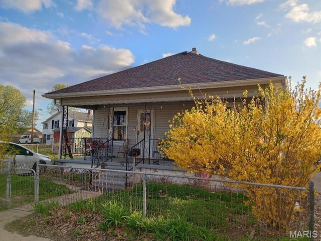 306 Kingshighway, East Alton, IL 62024 - view of front facade featuring a porch, a fenced front yard, and roof with shingles