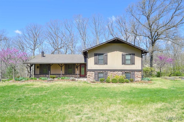 split level home featuring stone siding and a front yard
