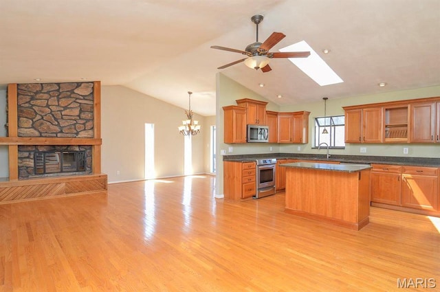 kitchen with appliances with stainless steel finishes, open floor plan, dark countertops, open shelves, and vaulted ceiling
