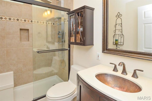 full bathroom featuring toilet, a stall shower, and vanity