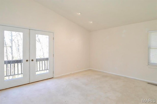 empty room featuring french doors, carpet, lofted ceiling, plenty of natural light, and baseboards