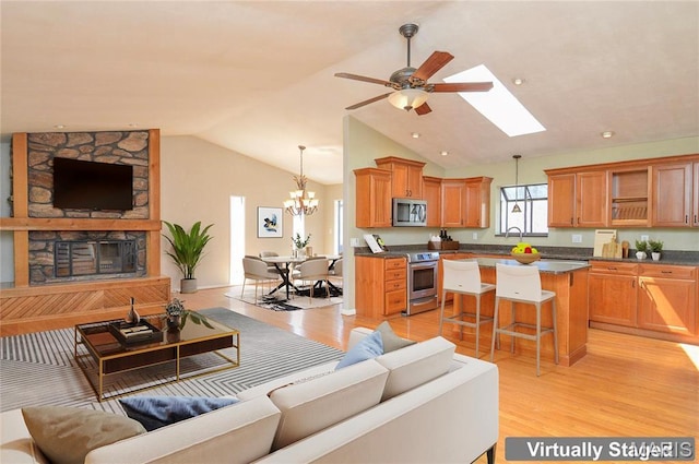 3019 Cedar Ridge Ln, Waterloo, IL 62298 - living area featuring lofted ceiling, a chandelier, light wood-style flooring, a ceiling fan, and a skylight