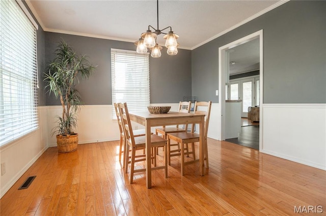 16747 Chalk Bluff Trl, Dexter, MO 63841 - dining area with a wainscoted wall, light wood-type flooring, ornamental molding, and a chandelier