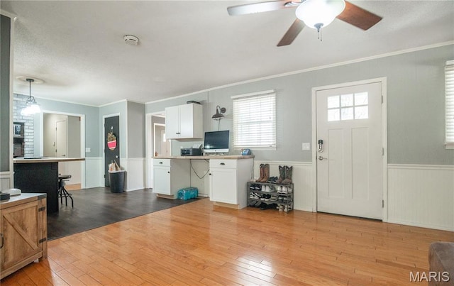 16747 Chalk Bluff Trl, Dexter, MO 63841 - entryway with wood-type flooring, wainscoting, crown molding, and a ceiling fan