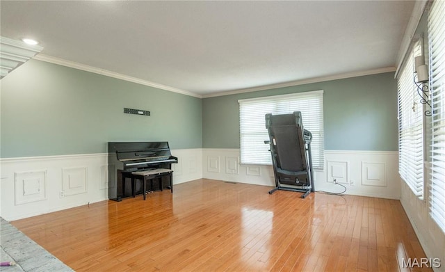 16747 Chalk Bluff Trl, Dexter, MO 63841 - living area featuring healthy amount of natural light, wainscoting, wood finished floors, ornamental molding, and a decorative wall