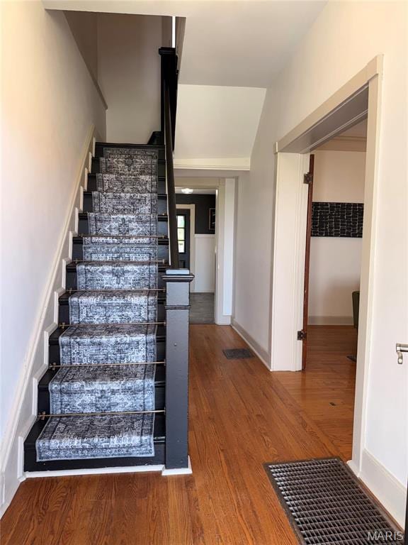 stairway with wood finished floors and baseboards