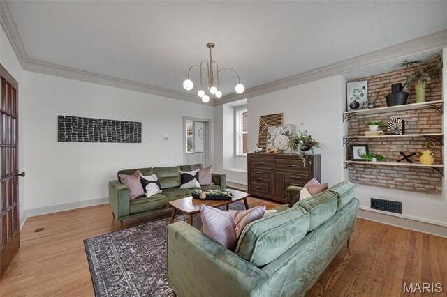 living area with wood finished floors, a chandelier, ornamental molding, and baseboards