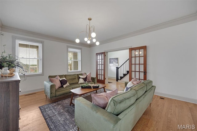 living room with ornamental molding, light wood finished floors, baseboards, and stairs