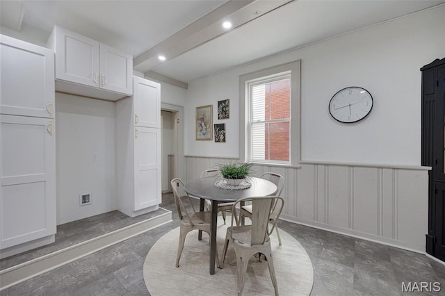 dining space with a decorative wall, wainscoting, and recessed lighting