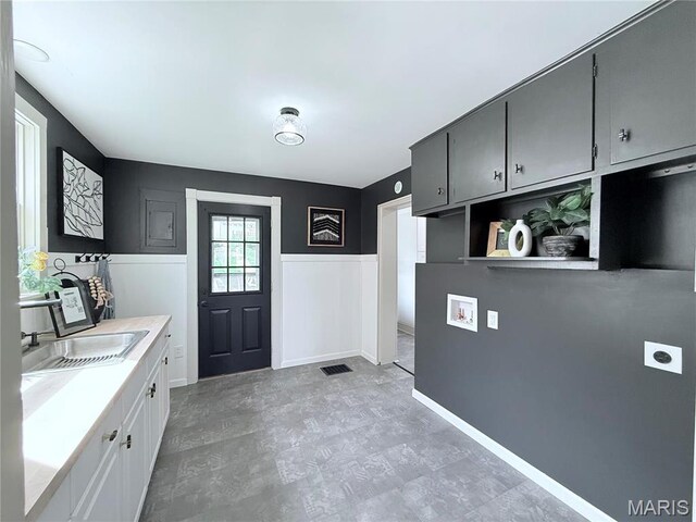 laundry area with a sink, hookup for an electric dryer, washer hookup, and light flooring
