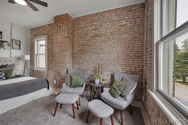carpeted bedroom featuring brick wall and a ceiling fan