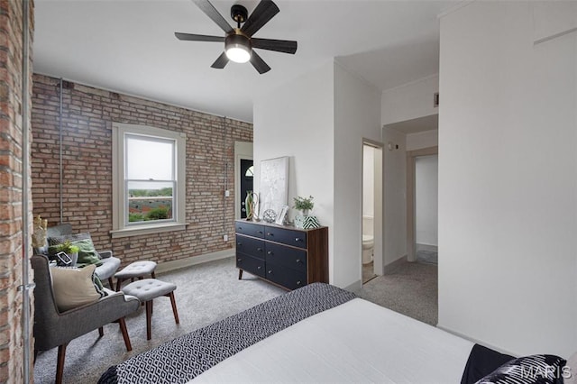 bedroom with brick wall, carpet, baseboards, connected bathroom, and ceiling fan