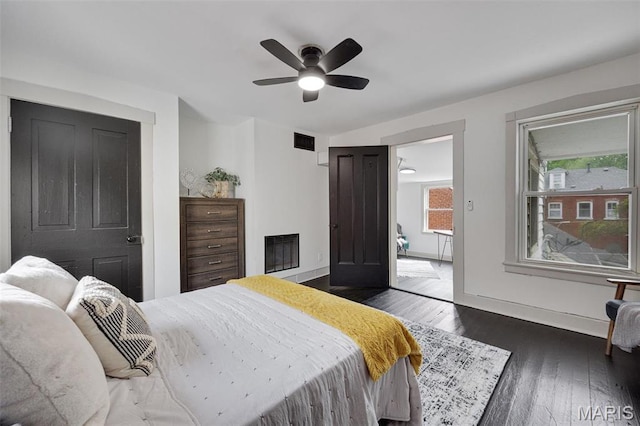 bedroom featuring wood finished floors, baseboards, and ceiling fan