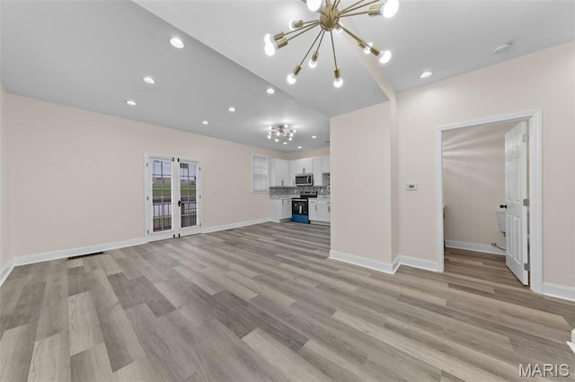 236 Georgia Ave, Saint Louis, MO 63135 - unfurnished living room featuring a chandelier, recessed lighting, light wood-style flooring, baseboards, and french doors