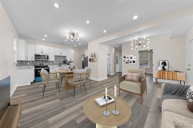 236 Georgia Ave, Saint Louis, MO 63135 - living area featuring a chandelier, baseboards, recessed lighting, and light wood-style floors