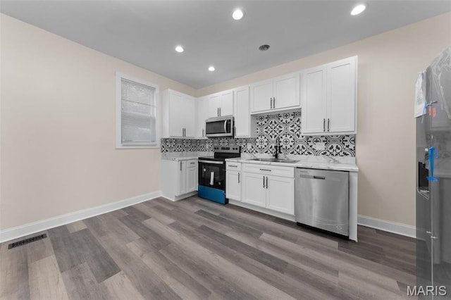 236 Georgia Ave, Saint Louis, MO 63135 - kitchen featuring appliances with stainless steel finishes, a sink, light countertops, baseboards, and recessed lighting