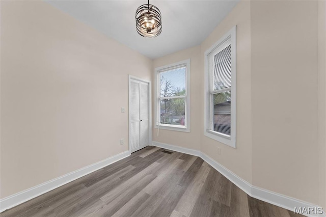 236 Georgia Ave, Saint Louis, MO 63135 - unfurnished room featuring dark wood-style floors, baseboards, and a chandelier