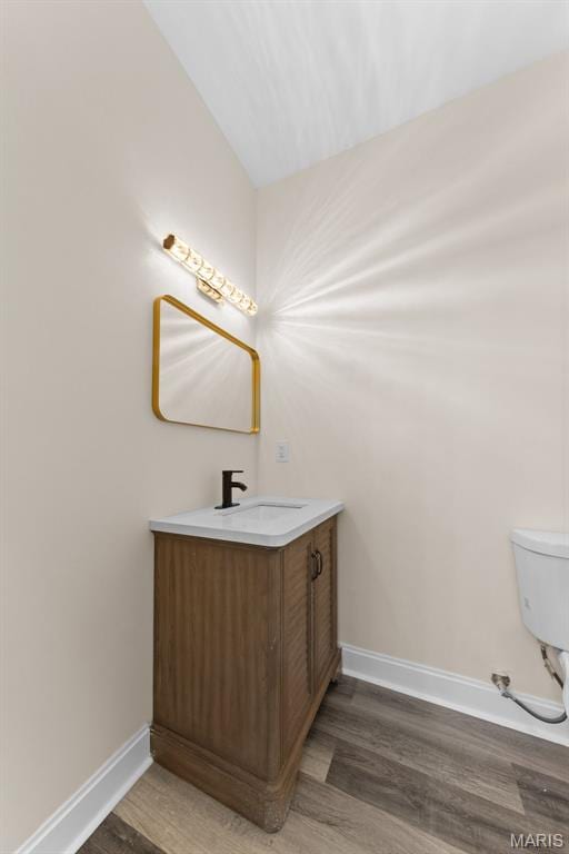 236 Georgia Ave, Saint Louis, MO 63135 - half bath featuring baseboards, wood finished floors, vanity, and toilet